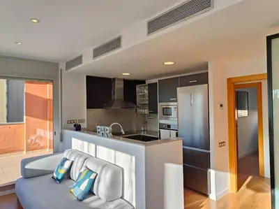 a kitchen with a blue couch in a room at Large terrace luxury apartment in Sant Adria de Besos