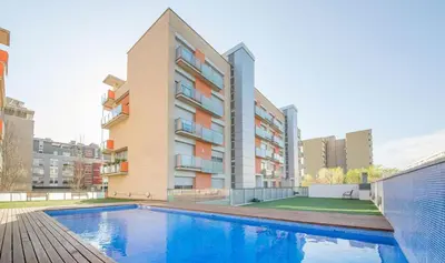 a swimming pool in front of a building at Large terrace luxury apartment in Sant Adria de Besos