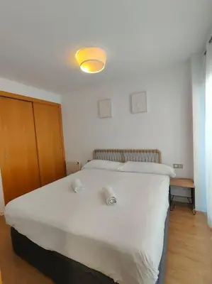 a bedroom with a white bed with a light on it at Large terrace luxury apartment in Sant Adria de Besos