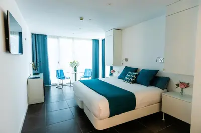 a bedroom with a large bed and a table with chairs at Hotel 54 Barceloneta in Barcelona