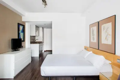 a bedroom with a white bed and a tv at Barcelona Apartment Aramunt in Barcelona