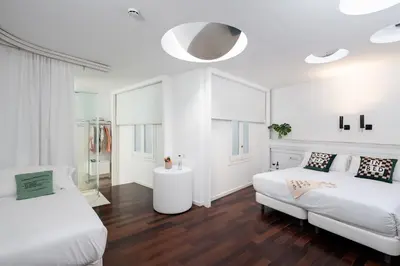 a white room with two beds and a mirror at Chic & Basic Born Boutique Hotel in Barcelona