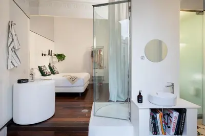 a bathroom with a shower and a bed at Chic & Basic Born Boutique Hotel in Barcelona
