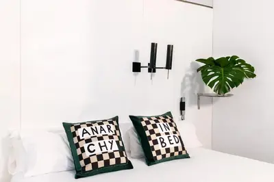 a white couch with two pillows and a plant on it at Chic & Basic Born Boutique Hotel in Barcelona