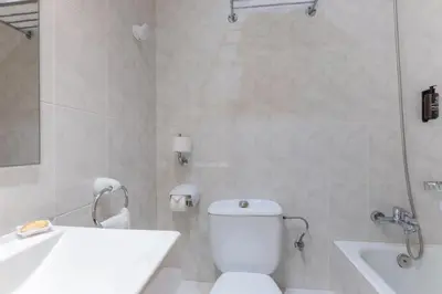 a white bathroom with a toilet and a sink at Hotel Lyon in Barcelona