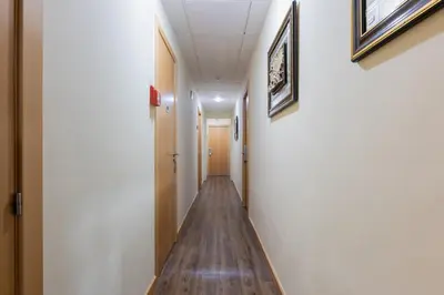 a hallway with a long wooden floor in a building at Hotel Lyon in Barcelona