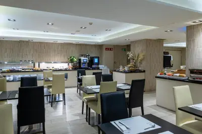a restaurant with tables and chairs and a counter at Hotel Santa Marta in Barcelona
