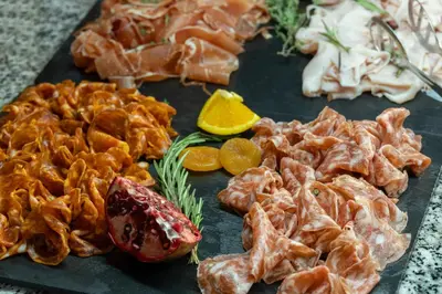 a tray of food with meat and fruits on a table at Hotel Rialto in Barcelona
