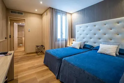 a bedroom with a blue bed with a large headboard at Hotel Rialto in Barcelona