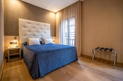 a bedroom with a large bed with a blue blanket at Hotel Rialto in Barcelona