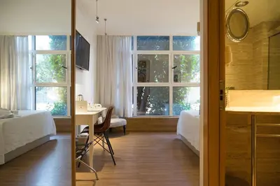 a room with two beds and a desk and a window at Vilana Hotel Boutique in Barcelona