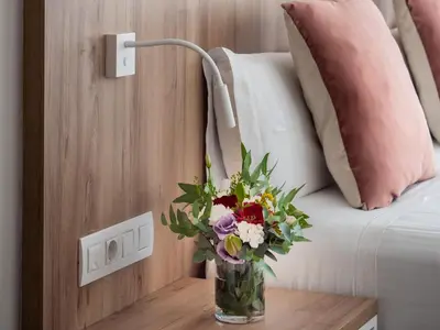 a vase of flowers on a table next to a bed at Vilana Hotel Boutique in Barcelona