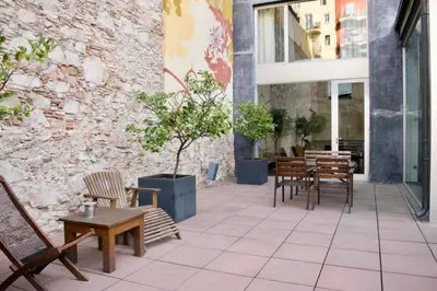 a patio with tables and chairs and a building at Onix Liceo in Barcelona