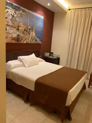 a bedroom with a large bed with a painting on the wall at Galeón in Sitges