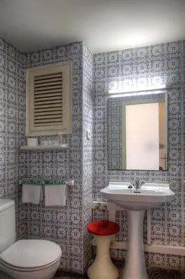 a bathroom with a sink and a toilet and a mirror at El Cid in Sitges
