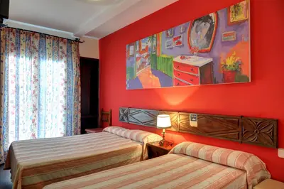 a bedroom with two beds and a painting on the wall at El Cid in Sitges