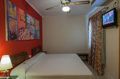 a bedroom with a bed and a flat screen tv at El Cid in Sitges