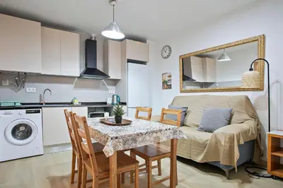 a kitchen and living room with a table and a couch at Beautiful apartment in Las Ramblas Barcelona 6pax in Barcelona