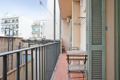 a balcony with chairs and tables on a building at Beautiful apartment in Las Ramblas Barcelona 6pax in Barcelona