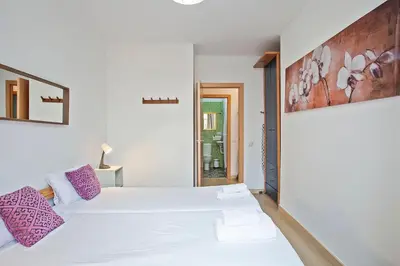a bedroom with a large white bed with purple pillows at Beautiful apartment in Las Ramblas Barcelona 6pax in Barcelona