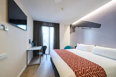 a hotel room with a large bed and a desk at Catalonia Avinyo in Barcelona