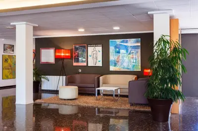 a lobby with a waiting room with couches and plants at Checkin Montserrat in Collbató