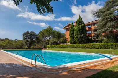 a swimming pool in front of a building at Checkin Montserrat in Collbató