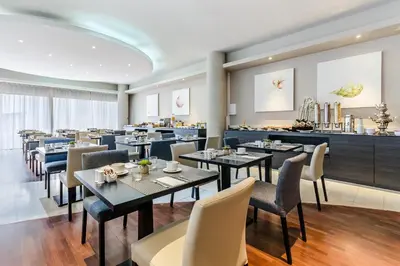 a restaurant with tables and chairs and a bar at Exe Campus in Bellaterra