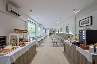 a large room with tables and chairs in a restaurant at Aparthotel Bcn Montjuic in Barcelona