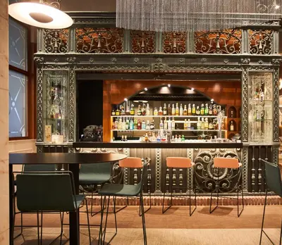 a bar with a table and chairs in a room at Silken Ramblas in Barcelona