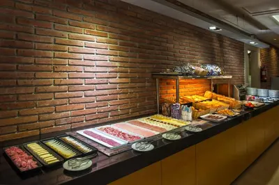 a bakery with a brick wall and a counter with food at Silken Ramblas in Barcelona