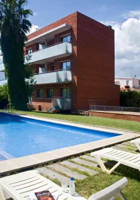 a swimming pool in front of a building at SG Costa BCN Apartments in Castelldefels