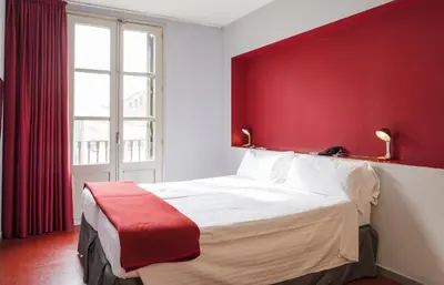 a bedroom with a large bed with a red wall at Ciutat Vella in Barcelona
