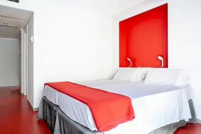 a bedroom with a white bed with a red headboard at Ciutat Vella in Barcelona