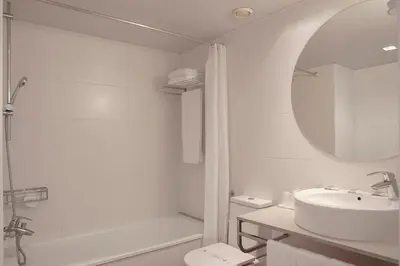 a white bathroom with a sink and a mirror at Ciutat Vella in Barcelona