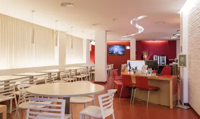 a restaurant with tables and chairs and red walls at Ciutat Vella in Barcelona
