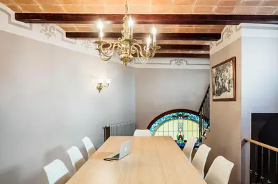 a dining room with a table and a chandelier at Balneari Termes Victòria in Caldes de Montbui