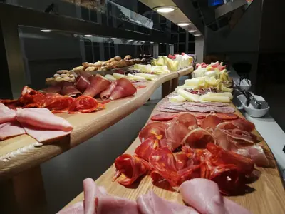 a buffet line with different types of meats and food at Balneari Termes Victòria in Caldes de Montbui