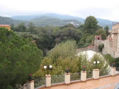 a balcony with a view of the mountains and trees at Balneari Termes Victòria in Caldes de Montbui