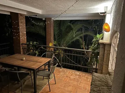 a wooden table and chairs on a balcony with plants at Costa Maresme Barcelona , Relax & Pool in Cabrils