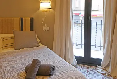 a bed in a room with a window and a bed with at Fridays Flats Onix House in Hospitalet de Llobregat