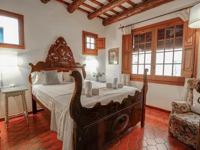 a bedroom with a large bed and a chair at Beach Villa Aralinn by Hello Homes Sitges in Sitges