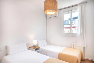 a room with two beds and a window at Cozy Apt with charm and exquisite natural light in Barcelona