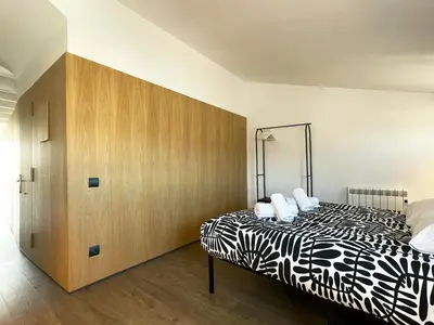 a bedroom with a black and white bed and a wooden cabinet at loft en el centro in Vilanova i la Geltrú