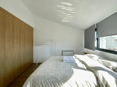a bedroom with a large bed and a window at loft en el centro in Vilanova i la Geltrú