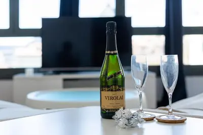 a bottle of wine sitting on a table with two glasses at Espectacular loft en centrico edificio singular in Manresa