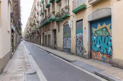 an empty street with graffiti on the side of a building at Barnapartments Raval in Barcelona