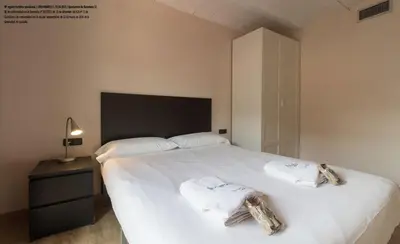 a bedroom with a large white bed with towels on it at Barnapartments Raval in Barcelona