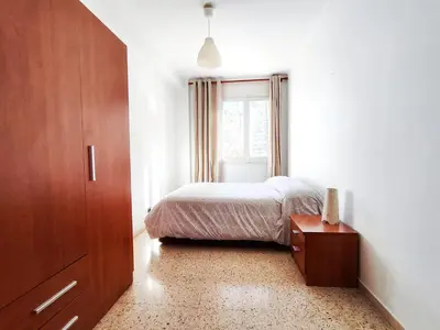 a bedroom with a bed and a dresser and a window at Apartamento Diagonal Mar, cerca del Forum y Playa in Barcelona