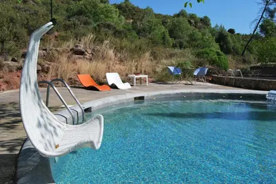 a swimming pool with chairs and a table at Masia Vilatersana in Sant Llorenc Savall